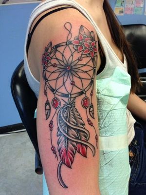  Tatouage attrape rêve noir et rouge sur le haut du bras